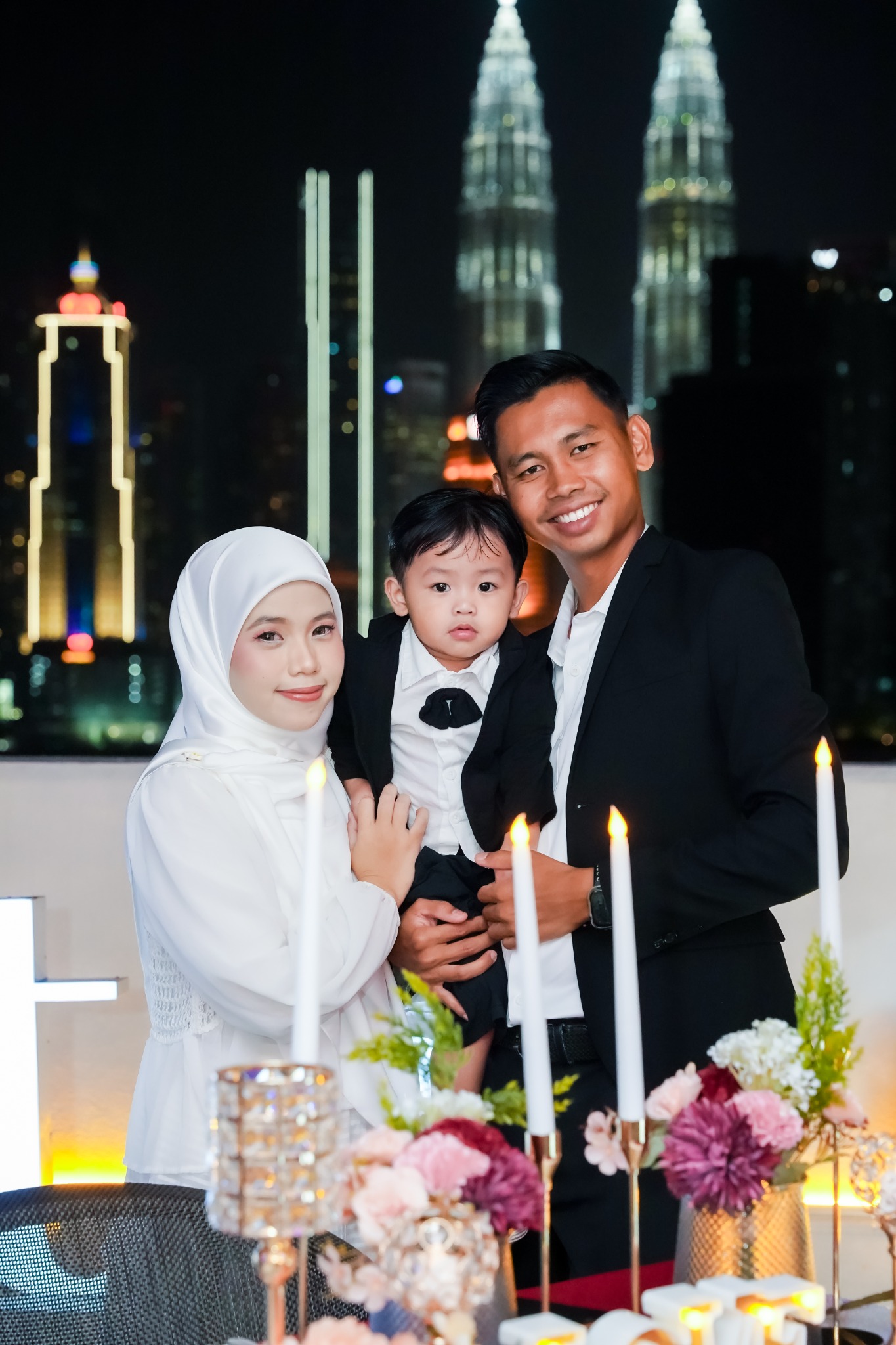 Wawa bersama suami dan anak, berlatar KLCC di Scarlett Rooftop