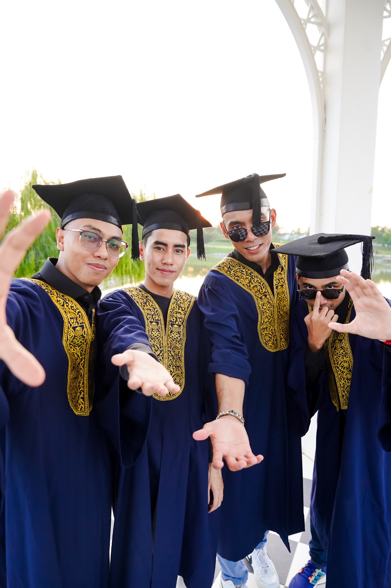 Empat rakan berjubah biru bergaya santai bersama dalam sesi Pre Convo.