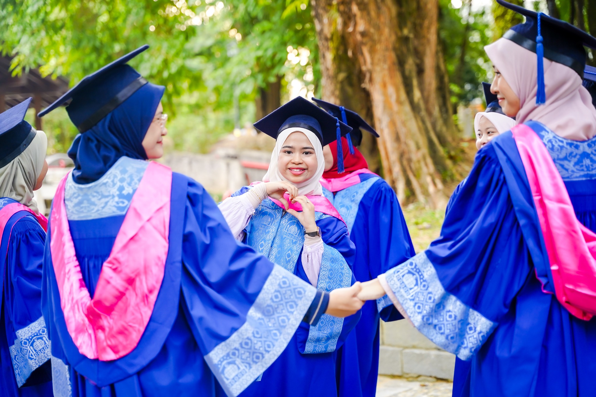 Sekumpulan rakan berjubah biru membentuk bulatan dalam sesi Pre Convo yang santai.