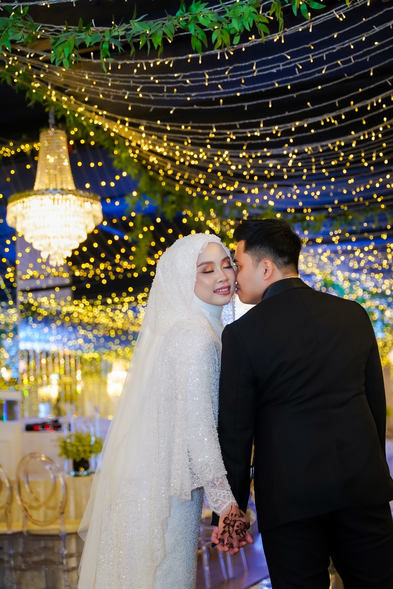 Wedding couple beneath golden lights