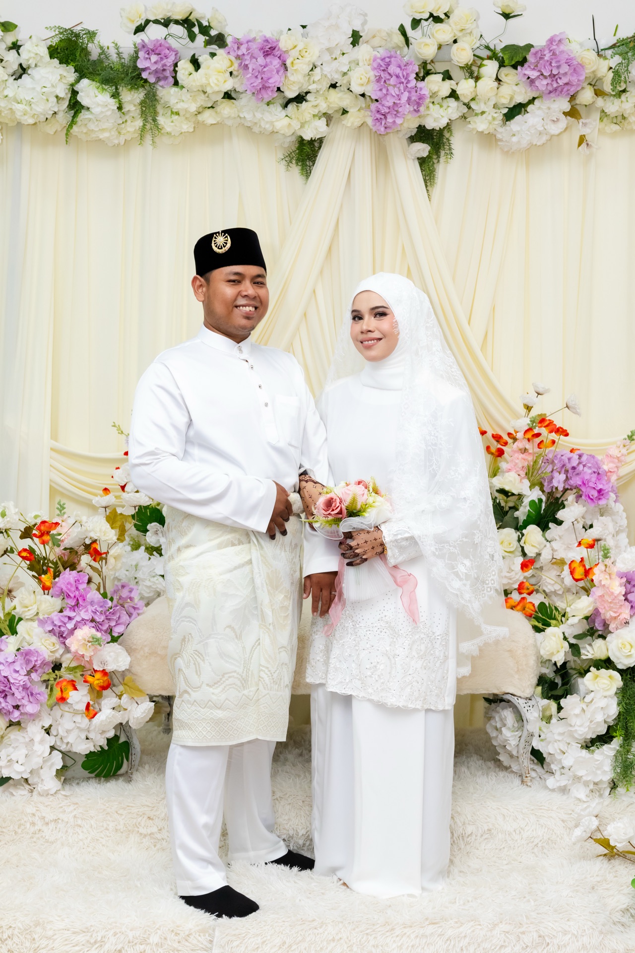 Newlyweds framed by white and lilac flowers